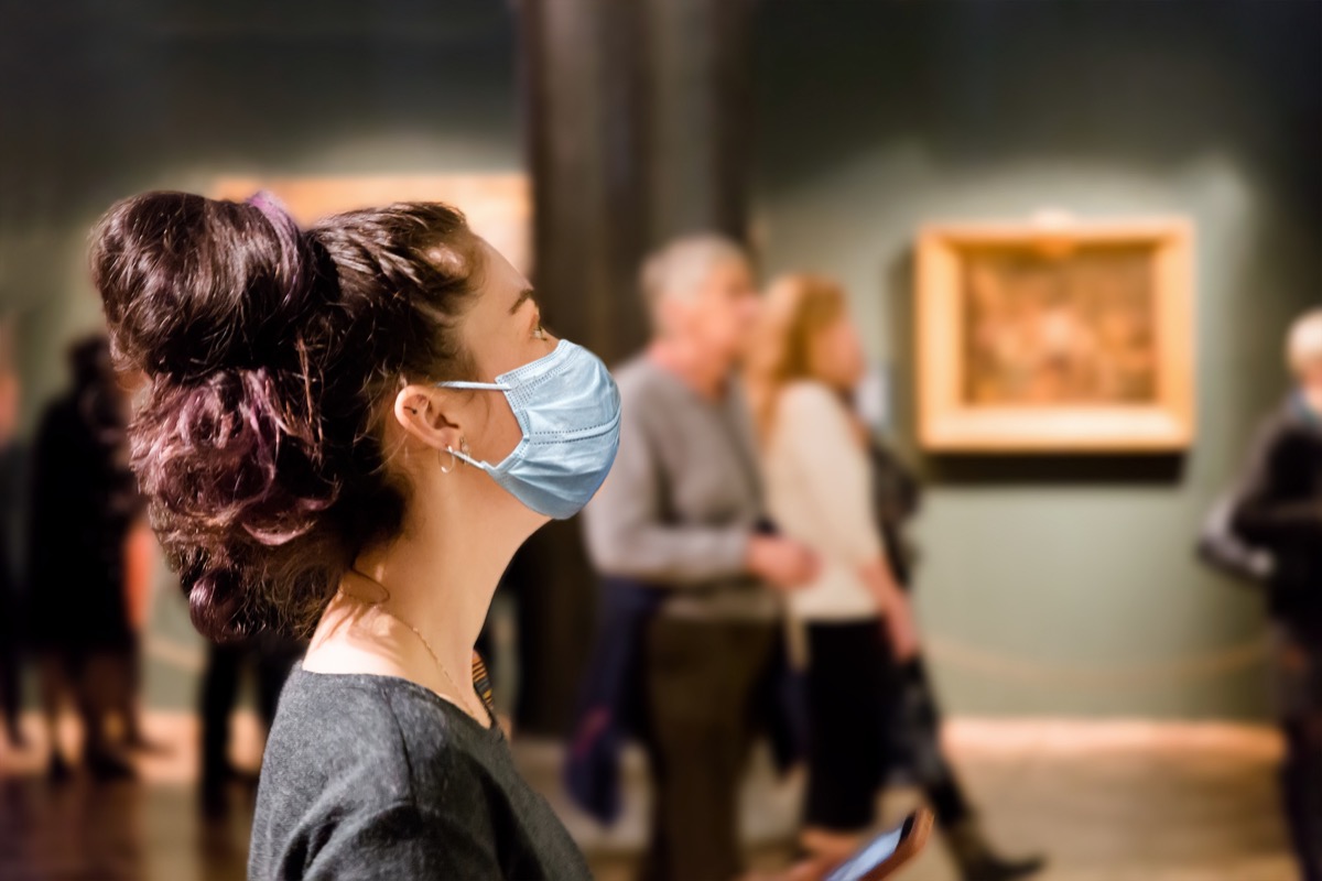 femme dans un musée portant un masque à cause de Covid